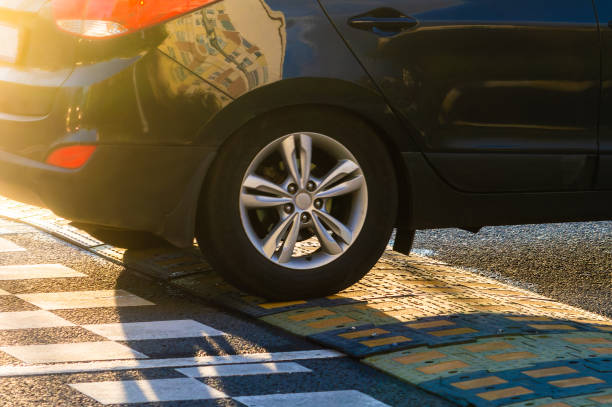 A passenger car drives over an speed bump on the road A passenger car drives over an speed bump on the road